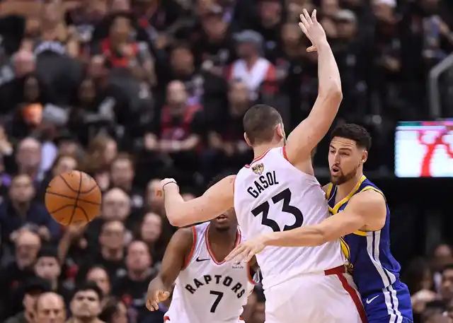 Golden State Warriors guard Klay Thompson (11) makes a pass behind Toronto Raptors center Marc Gasol (33) during the second half of Game 1 of basketball’s NBA Finals, Thursday, May 30, 2019, in Toronto. 