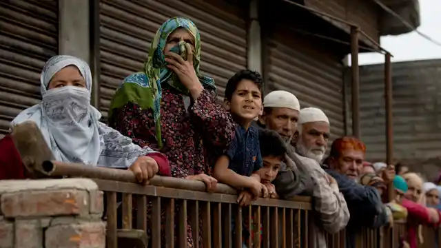 Kashmiri villagers watch funeral procession of slain militant Naseer Pandith, in Pulwama, Kashmir. 