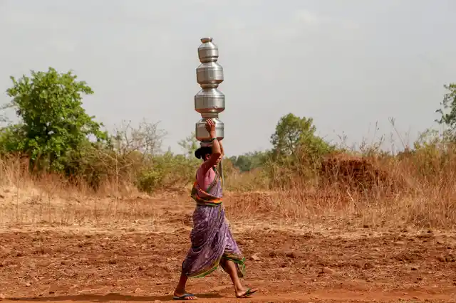 A woman carries multiple pots as she fetches water from a well, in Dhasai village of Thane district. Dhasai, claimed to be among the earliest villages to have implemented cash-less transactions, is facing an acute water shortage as all the wells in the village have dried up.