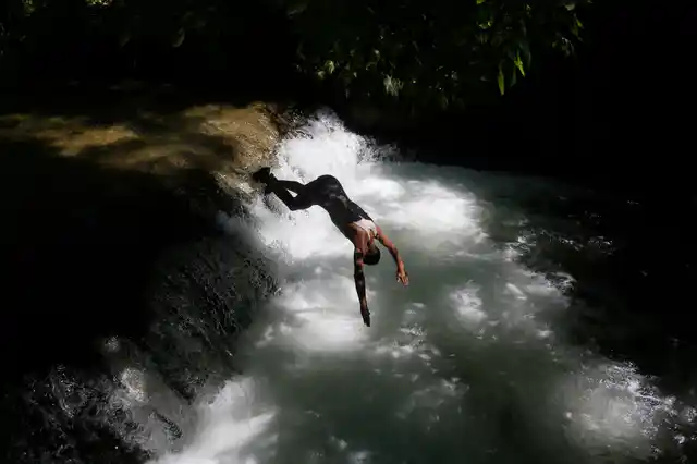 A Kashmiri boy dives into a stream to cool off on the outskirts of Srinagar. 