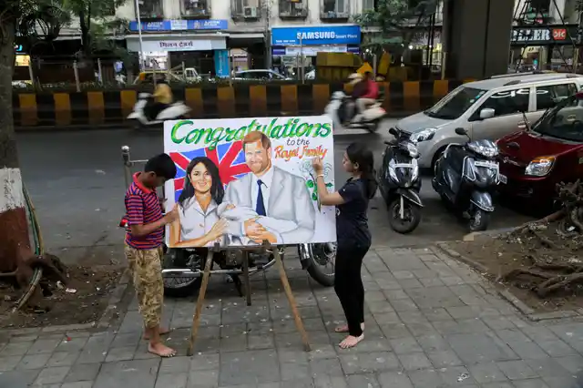 Students of an art school paint a poster to congratulate Britain’s Prince Harry and Meghan, the Duchess of Sussex, for the birth of their son Archie Harrison, in Mumbai.