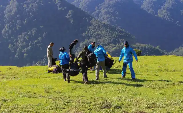 Members of a rescue team prepare to camp overnight, due to difficult terrain and weather, and move to the AN-32 crash site the next day, near North Lipo on Wednesday, 12 June.
