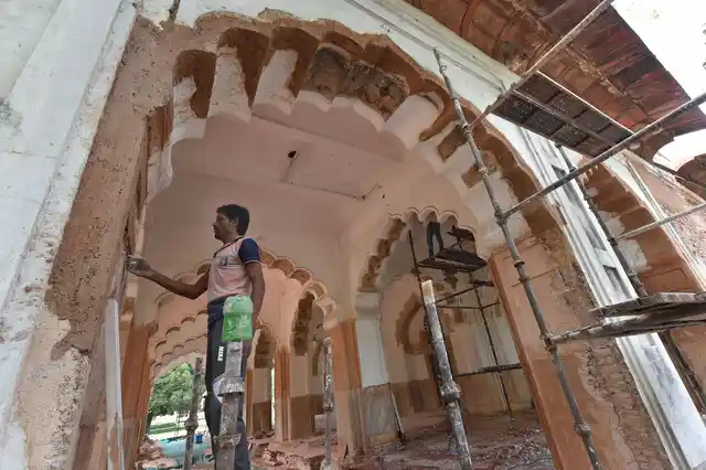 A worker repairs a wall using traditional material and techniques during the restoration of Mumtaz Mahal at Red Fort premises, in New Delhi, on 24 June.