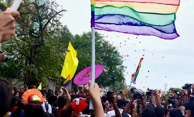 The Pride flag flies high, spreading love and hues.