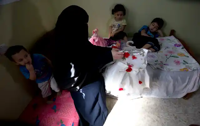 Muna Awad, mother of 5-year-old Aisha a-Lulu, and her children sit on what used to be Aisha’s bed at the family home in Burij refugee camp in central Gaza Strip.