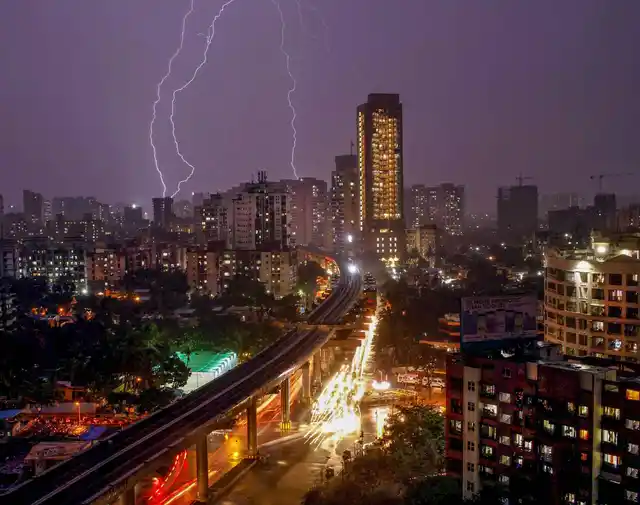 Bolts of lightning flash across the sky during thunderstorm and rain over the suburbs, in Mumbai, late Monday, 10 June. 
