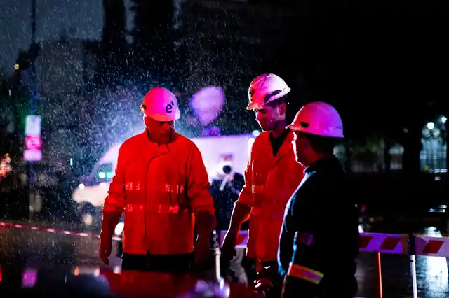 Technicians of Edenor electricity company stand under the rain as they work to fix a generator in Buenos Aires.