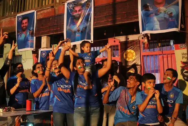 Fans cheer as they watch on television Cricket World Cup match between India and Pakistan, at a residential building in Mumbai on Sunday, 16 June, 2019. 