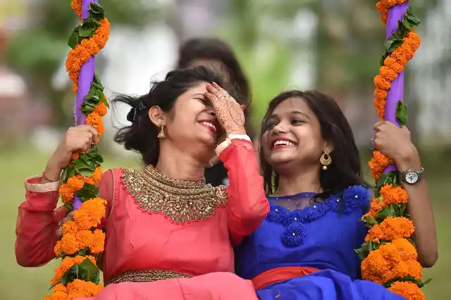 Girls enjoy on a swing on the 1st day of Raja festival celebrating womanhood in Bhubaneswar, Odisha on Thursday, 13 June.