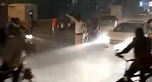 Mumbai cop managing traffic without a raincoat. 