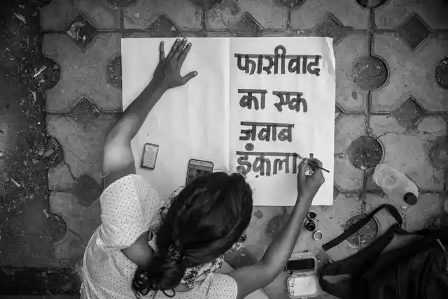 A woman prepares a placard bearing the word ‘Fasivaad (Fascism)‘ at the Jantar Mantar protest on Wednesday, 26 June. 