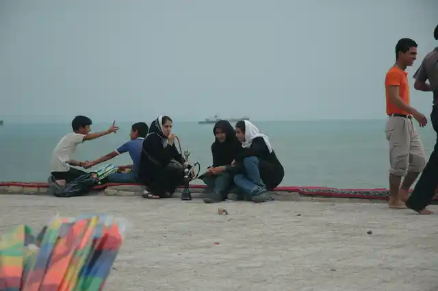 Girls sitting by the sea smoking the water-pipe in Bandar Abbas.