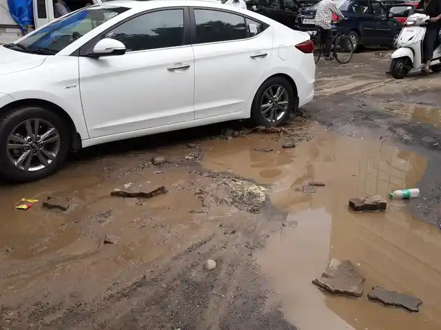 A pothole and a muddy road at Jogeshwari East. 
