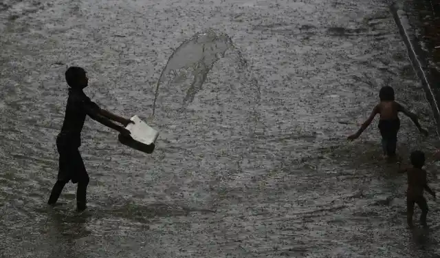 Children play at a waterlogged street during monsoon rains in Mumbai.