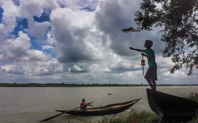 A boy flies a kite near the banks of River Hoogly in Nadia district on Wednesday, 3 July.