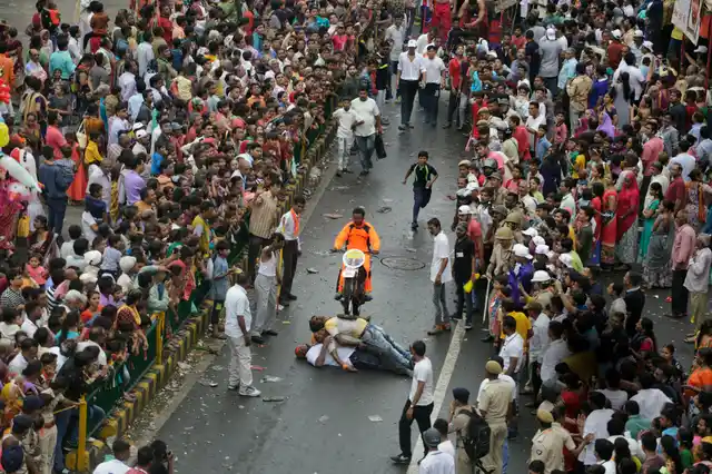 A man performs a bike stunt during the annual festival of Rath Yatra.