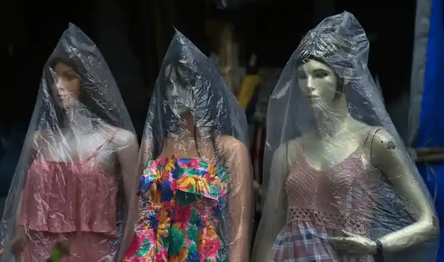 Mannequins outside a clothing store are covered with plastic to protect from rains in Mumbai.