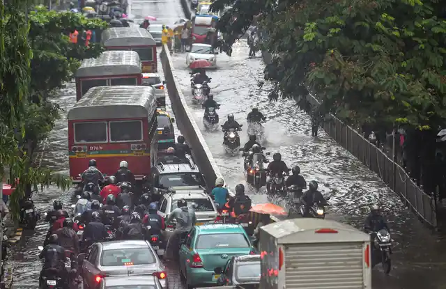 Vehicles move slowly through waterlogged streets during heavy monsoon rain in Mumbai on Monday.