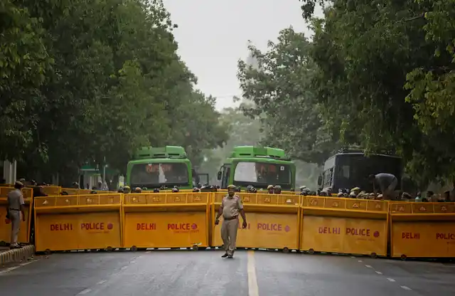 A Delhi police officer stands in front of police barricades ahead of protest by Congress party supporters near the parliament on Tuesday, 9 July, 2019. The Congress party protesters accused the ruling Bharatiya Janata Party (BJP) leadership of trying to pull down its coalition government in Karnataka.