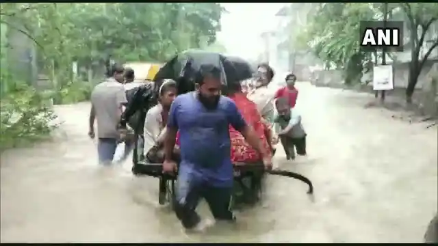 People wade through chest-deep water in Bhiwandi. Several parts of the state are flooded due to heavy rainfall.