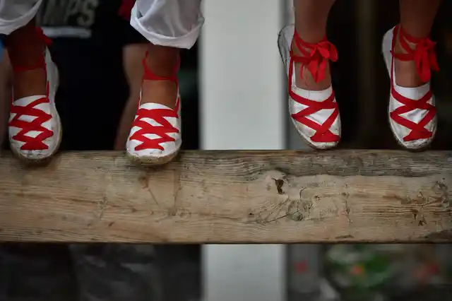 Revellers sit atop of a wooden barrier during the running of the bulls at the San Fermin Festival, in Pamplona.