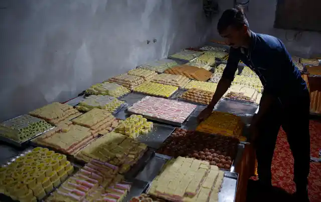 An Indian vendor displays sweets for sale on Diwali, in Uttar Pradesh’s Ayodhya.