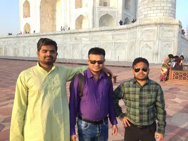 Basanta Behera, Ananta Kumar Nayak, and Amit Kumar Mohanty pose in front of the Taj Mahal.