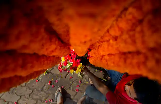 A vendor arranges flower at his roadside temporary shop in Gauhati, India.