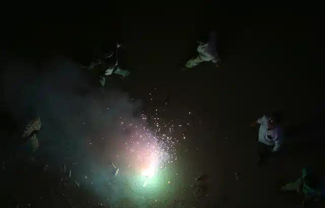 People light fire crackers on a street during Diwali festival in Hyderabad.
