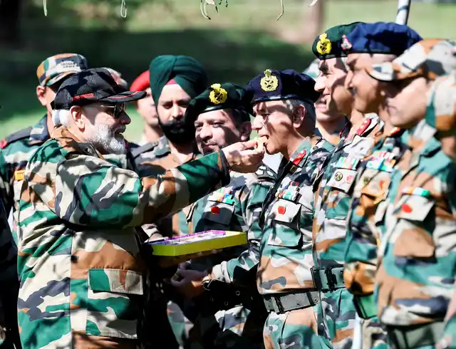 Prime Minister Narendra Modi feeds sweets to Indian Army personnel during Diwali celebrations in Rajouri district, Jammu and Kashmir. PM Modi was in Rajouri for Diwali, to meet with jawans on duty.