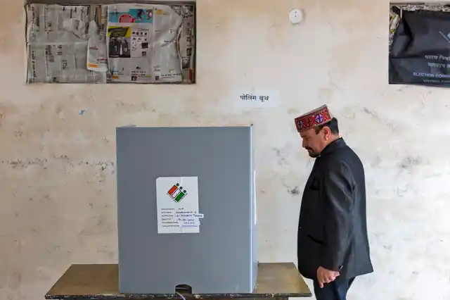 A voter walks to a polling enclosure to cast his ballot in a bypoll for an assembly seat in Dharmsala, India, Monday, 21 Oct 2019.