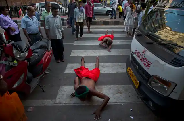 Indian devotees move while lying prostrate to reach the river Brahmaputra during Chhath Puja festival in in Gauhati.