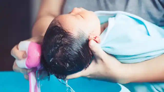 Parent washing baby’s hair.