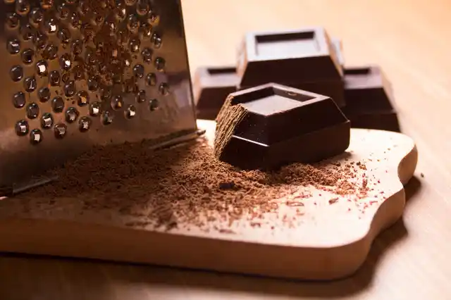 Grate chocolate in bulk - enough to sprinkle over the cupcakes for your dinner party.