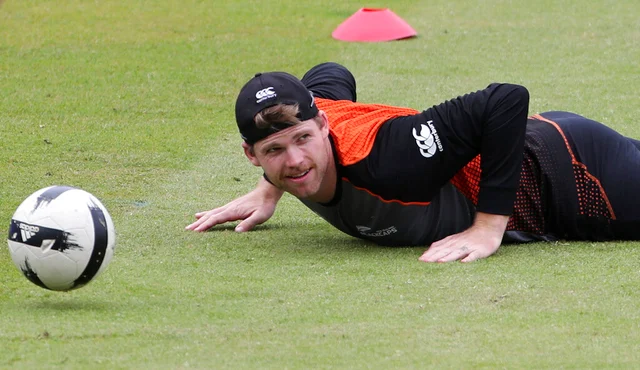 New Zealand's Lockie Ferguson falls on the ground while playing with a soccer ball during a training session ahead of their Cricket World Cup semifinal match against India at Old Trafford in Manchester.