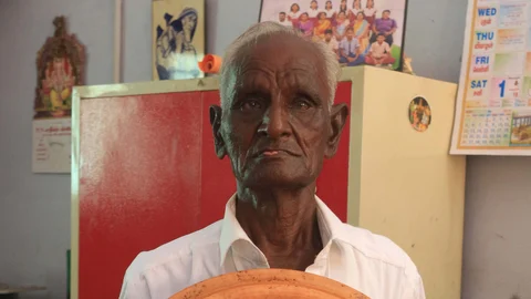 தமிழ் எண்கள் கொண்ட கடிகாரத்துடன் மாரியப்பன்
