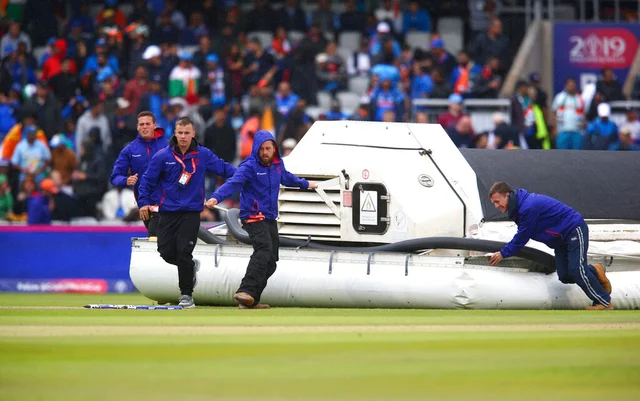 Groundsmen bring out a water removal machine as it rains during the Cricket World Cup semifinal match between India and New Zealand at Old Trafford in Manchester.