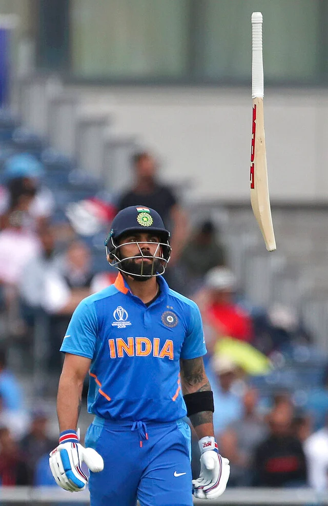 India's captain Virat Kohli throws his bat in frustration after being dismissed by New Zealand's Trent Boult.