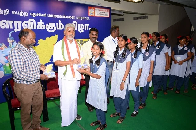 அமைச்சரிடம் பரிசு பெறும் மாணவிகள்