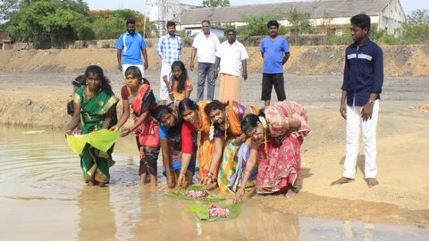 குளத்தில் ஆடிப்பெருக்கு கொண்டாடும் மக்கள்
