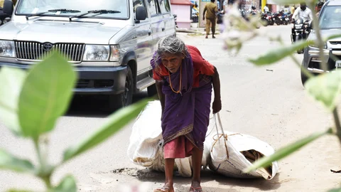 A 75-year elder woman collecting empty boxes for livelihood