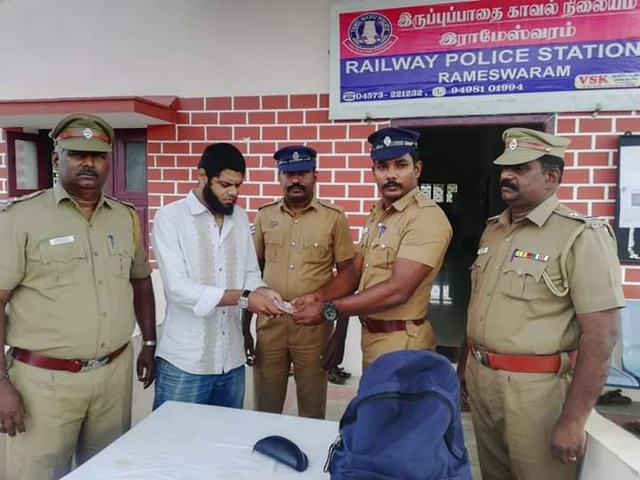 ரயில் பயணியிடம் பணத்தை ஒப்படைக்கும் போலீஸார்
