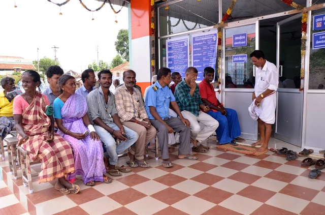 நிழலில் அமர்ந்துள்ள பொதுமக்கள்