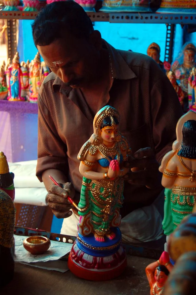 கொலு பொம்மைகளுக்கு வர்ணம் தீட்டும் தொழிலாளி
