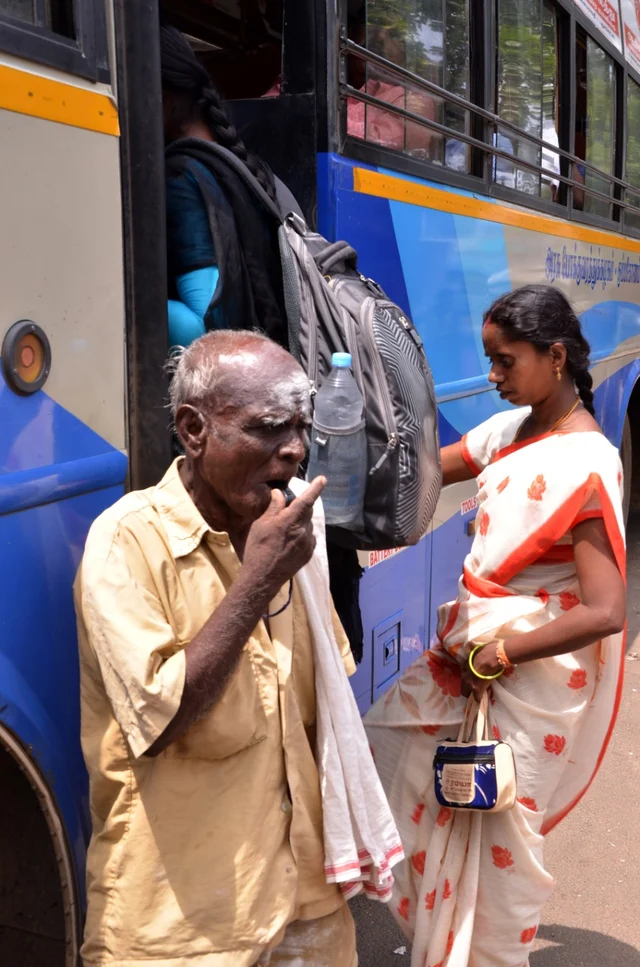 விசில் அடித்து பேருந்து சிக்னல் கொடுக்கிறார்.