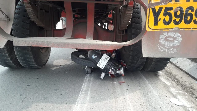 லாரியின் அடியில் கிடக்கும் டூவீலர்