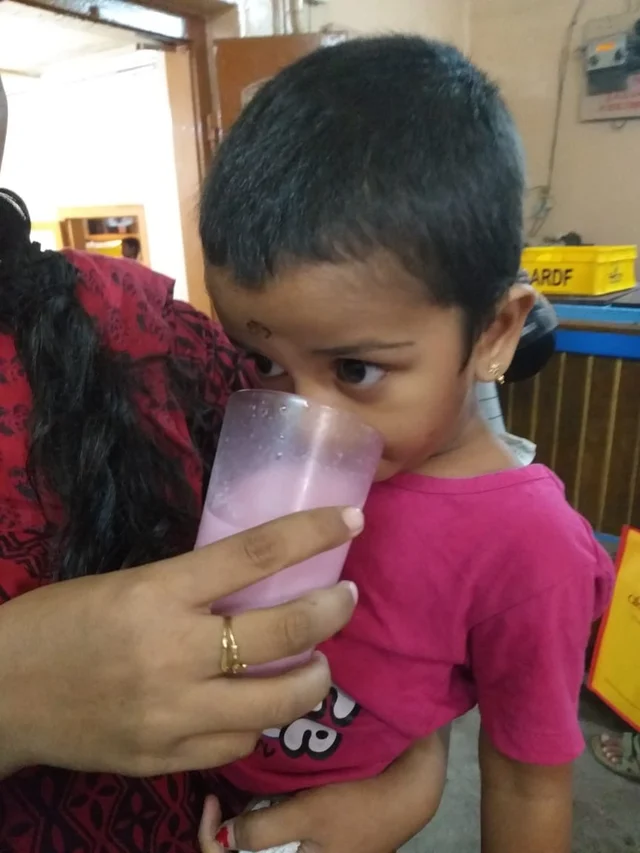 ரோஸ் மில்க் குடுக்கும் சிறுமி.
