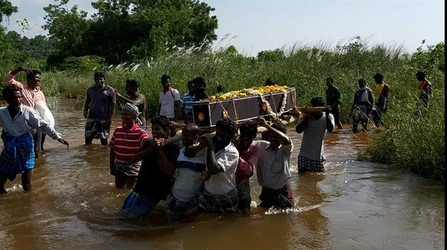 தண்ணீரில் கொண்டு செல்லப்படும் இறந்தவர் உடல்