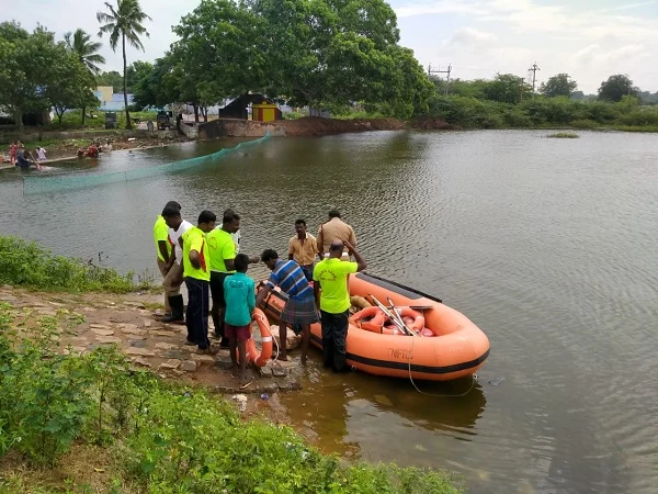 குளத்தில் முதலையைத் தேடும் தீயணைப்பு வீரர்கள்.
