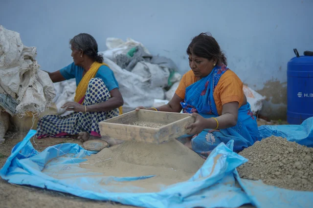 வெடி மருந்து அடைக்கப்படும் குழாய்க்கு மண் சலிக்கும் தொழிலாளிகள்.